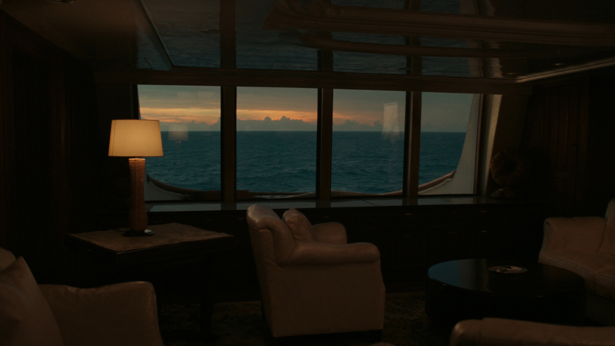 Salão do iate ao entardecer com o mar na janela